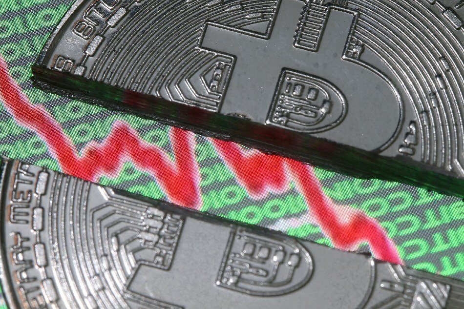 Broken representation of the Bitcoin virtual currency, placed on a monitor that displays stock graph and binary codes, are seen in this illustration picture, December 21, 2017. Dado Ruvic, Reuters/File
