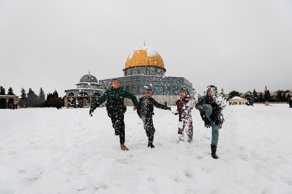Children kick snow by the Dome of the Rock, located in Jerusalem's Old City on the compound known to Muslims as Noble Sanctuary and to Jews as Temple Mount during a snowy morning in Jerusalem's Old City, January 27, 2022. Ammar Awad, Reuters