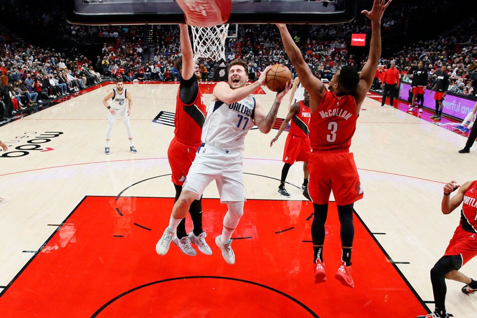 Dallas Mavericks point guard Luka Doncic (77) is fouled while shooting by Portland Trail Blazers shooting guard CJ McCollum (3) during the first half at Moda Center. Soobum Im, USA TODAY Sports/Reuters.