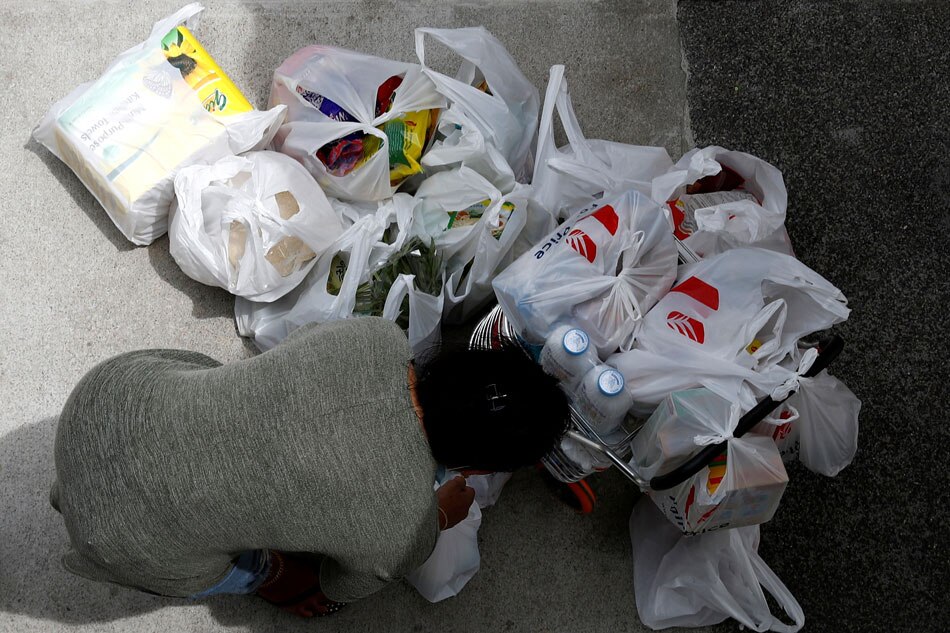 A woman packs her grocery shopping outside a supermarket in Singapore on February 8, 2020. Edgar Su, Reuters/File Photo