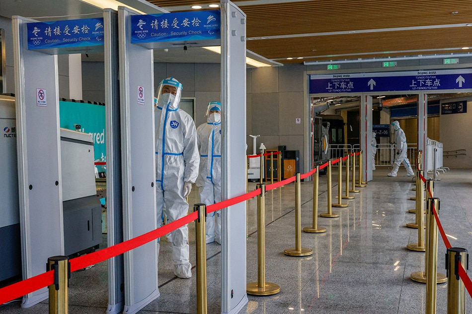 Security guards wearing personal protective equipment, wait to check people arriving on the high-speed train from Beijing inside a closed loop area designed to prevent the spread of COVID-19 ahead of the Beijing 2022 Winter Olympics, in Zhangjiakou, China, Jan. 27, 2022. Tyrone Siu, Reuters