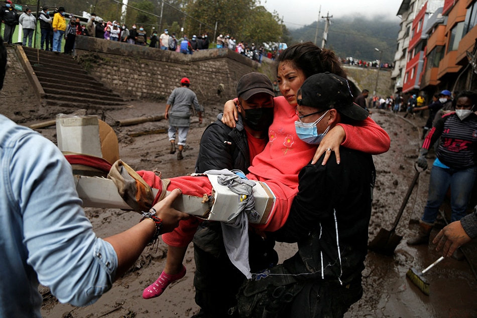 Karen Maite, 16, is helped by rescue crews in an area of a landslide in Quito, Ecuador, Feb. 1, 2022. Jonatan Rosas, Reuters