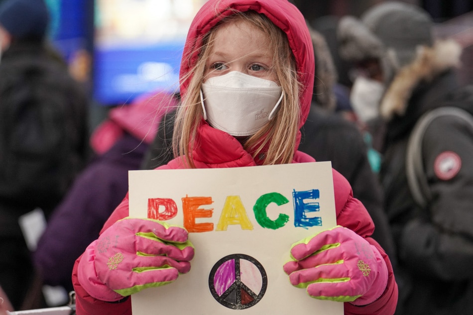 A girl holds a 'peace' sign during a protest against US military involvement in the brewing conflict between Russia and Ukraine during a rally at Times Square in New York, on Feb. 5, 2022. Chery Dieu-Nalio, AFP
