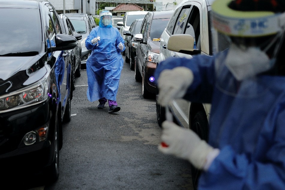 Medical workers prepare to take swab samples from people at a drive-thru coronavirus (COVID-19) test station, as the Omicron coronavirus variant spreads, in Jakarta, Indonesia. Willy Kurniawan Reuters