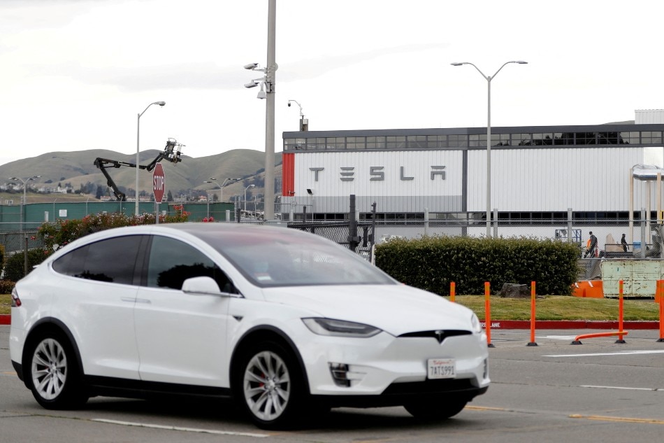  A Tesla vehicle drives past Tesla's primary vehicle factory after CEO Elon Musk announced he was defying local officials' coronavirus disease (COVID-19) restrictions by reopening the plant in Fremont, California, U.S. May 11, 2020. Stephen Lam, Reuters/File Photo/File Photo