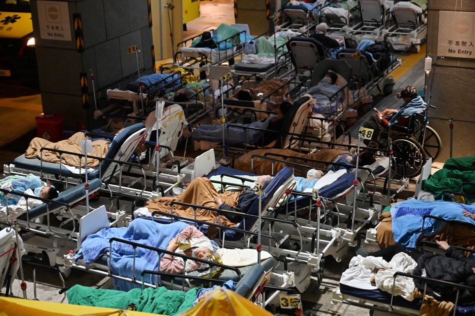 People lie in hospital beds with temperatures falling at nighttime outside the Caritas Medical Centre in Hong Kong on Wednesday, as hospitals become overwhelmed with the city facing its worst COVID-19 coronavirus wave to date. AFP