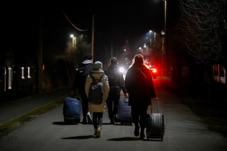 People walk after arriving from Ukraine to Slovakia, after Russian President Vladimir Putin authorized a military operation in Ukraine, through a border crossing in Velke Slemence, Slovakia, February 24, 2022. Radovan Stoklasa, Reuters