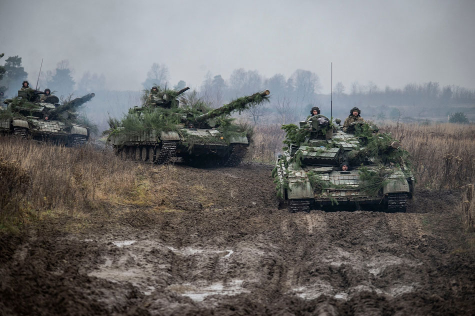 Ukrainian service members ride atop tanks during tactical drills at a training ground in an unknown location in Ukraine, in this handout picture released Feb. 22, 2022. Press service of the Ukrainian Armed Forces General Staff/Handout/Reuters