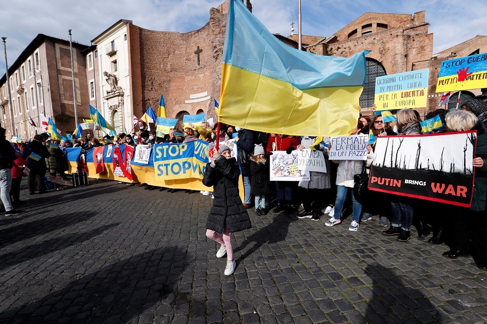 People hold Ukrainian flags and signs during an anti-war protest, after Russia launched a massive military operation against Ukraine, in Rome, Italy, February 27, 2022. REUTERS/Remo Casilli