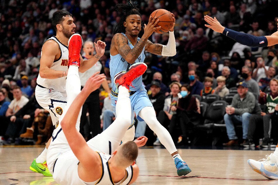 Memphis guard Ja Morant drives to the basket, as Nuggets center Nikola Jokic falls in their game January 21, 2022. Ron Chenoy, USA Today Sports/Reuters