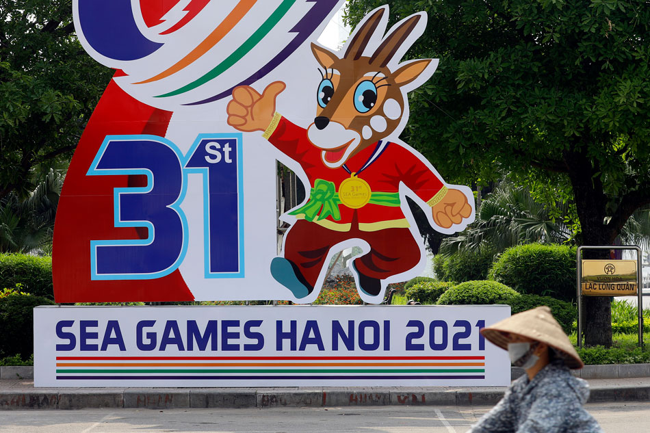  A woman rides bicycle past a banner advertising the upcoming 31st Southeast Asian Games in Hanoi, Vietnam, 25 April 2022. Luong Thai Linh, EPA-EFE.
