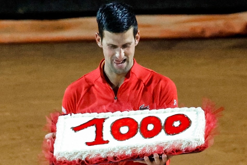 Serbia's Novak Djokovic holds a cake with the number of his 1,000th tour-level win earned after winning his men's singles semifinal match against Casper Ruud of Norway at the Italian Open tennis tournament in Rome, Italy, 14 May 2022. Fabio Frustaci, EPA-EFE.