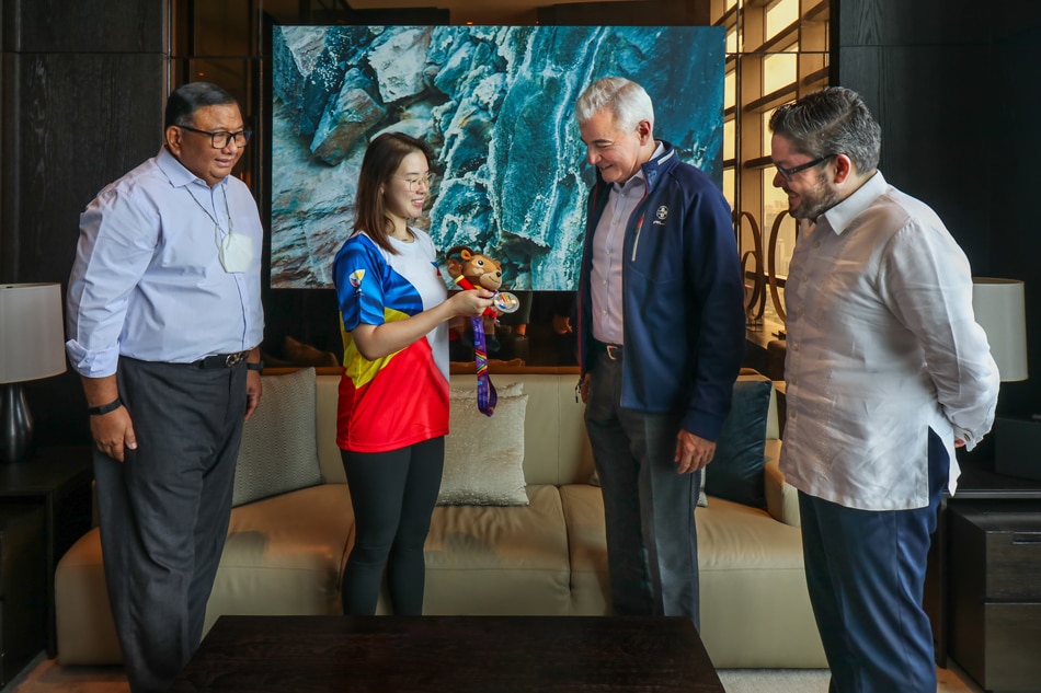 Filipina bowler Alexis Sy presents her silver medal to Ayala Corporation president & CEO Fernando Zobel de Ayala. Handout