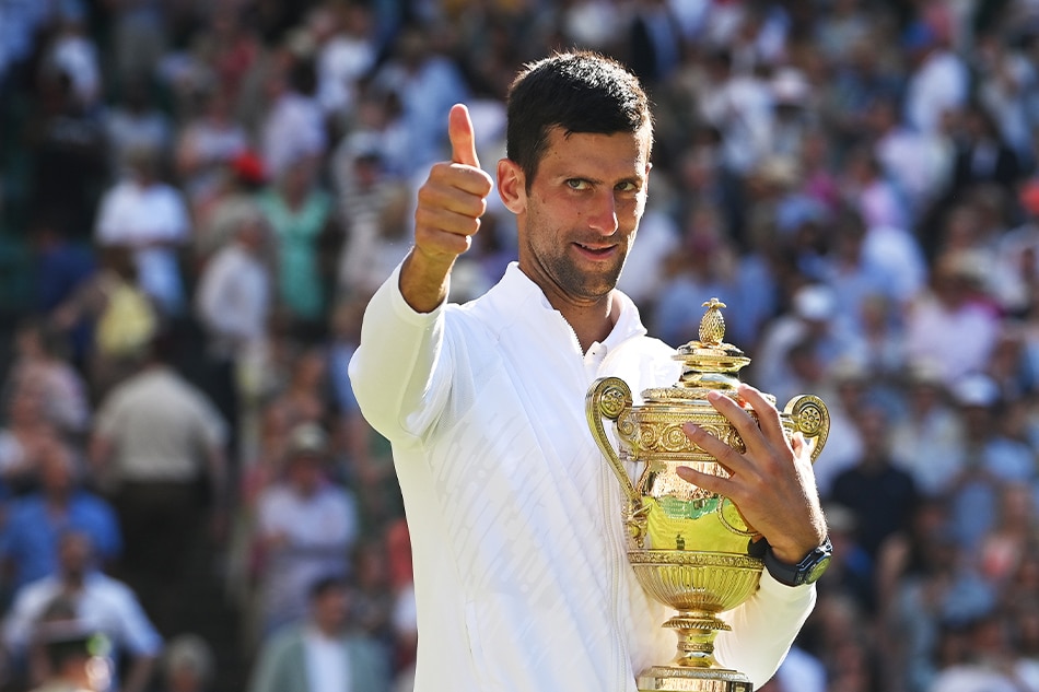 Novak Djokovic of Serbia holds the trophy and gives the thumbs-up sign after winning the men's final match against Nick Kyrgios of Australia at the Wimbledon Championships, July 10, 2022. Neil Hall, EPA-EFE