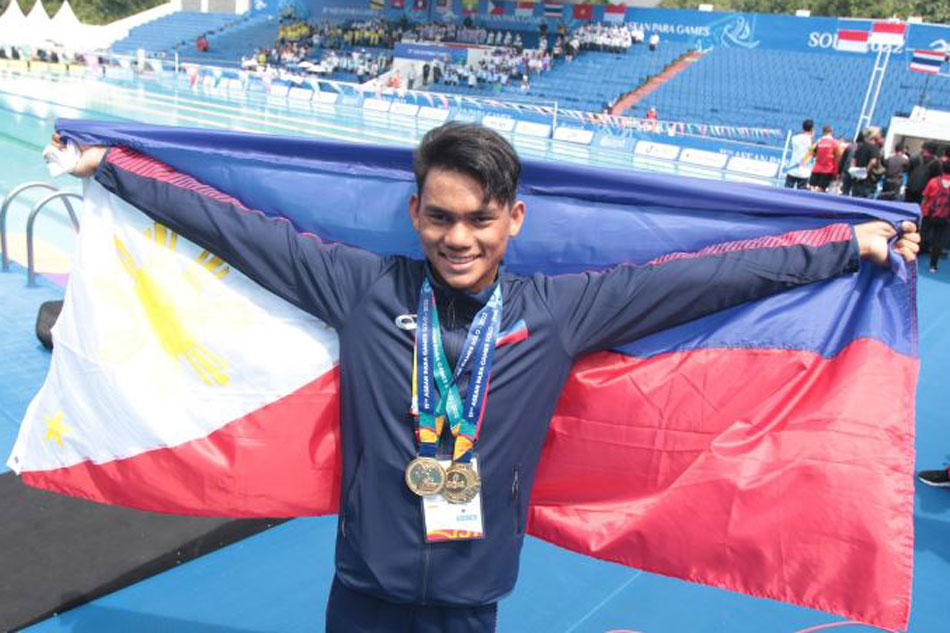 Ariel Joseph Alegarbes proudly displays the two gold medals he won in the swimming competition of the 11th ASEAN Para Games in Semarang, Indonesia. Handout