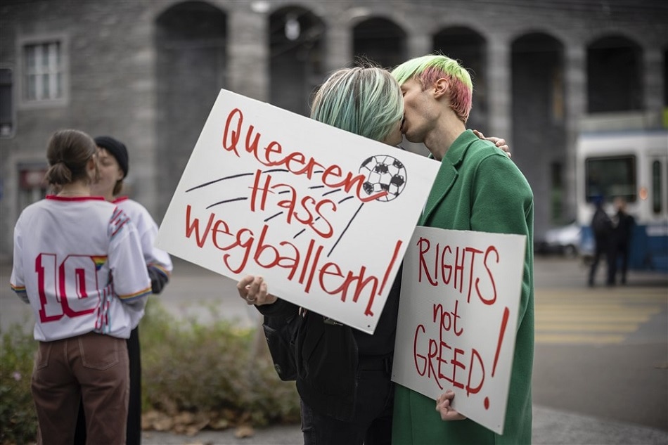 Protestors kiss in front of the FIFA Museum in Zurich, Switzerland, on November 9, 2022, while holding placards reading 'shoot out queer hate' and 'rights not greed' during a rally to raise awareness of the human rights situation of LGBT+ people in Qatar. Michael Buholzer, EPA-EFE
