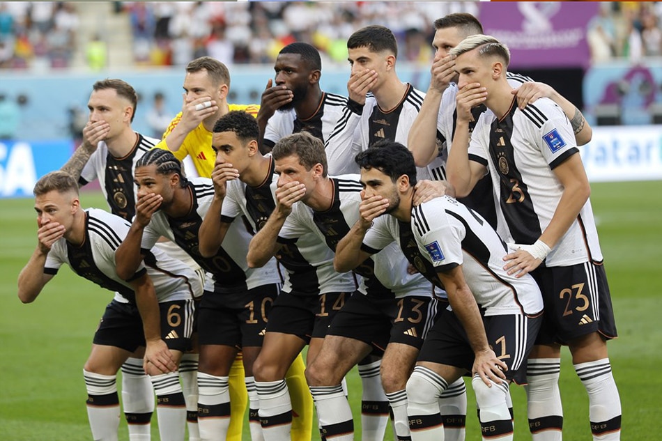 The starting XI of Germany cover their mouths as they pose for a team photo before their match with Japan in Doha, Qatar on November 23, 2022. Ronald Wittek, EPA-EFE
