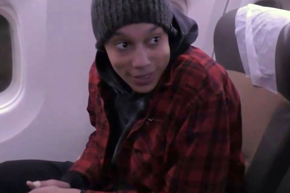 This video grab taken from a footage shown by Russian state media that AFP couldn’t independently authenticate shows US basketball star Brittney Griner sitting on a plane after being released from the prison where she was detained on December 8, 2022 in Moscow. She was accused of possession of vape cartridges with a small quantity of cannabis oil and sentenced in August to nine years in prison. Russian State Media/AFP