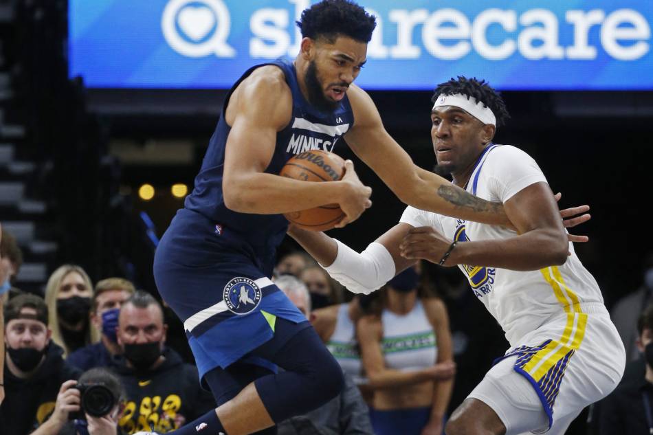 Minnesota Timberwolves center Karl-Anthony Towns (32) protects the ball as he tries to get around Golden State Warriors forward Kevon Looney (5) in the first quarter at Target Center. Bruce Kluckhohn, USA TODAY Sports/Reuters.