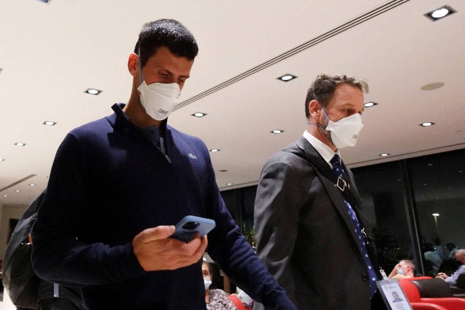 Serbian tennis player Novak Djokovic walks in Melbourne Airport before boarding a flight, after the Federal Court upheld a government decision to cancel his visa to play in the Australian Open, in Melbourne, Australia, January 16, 2022. Loren Elliott, Reuters.