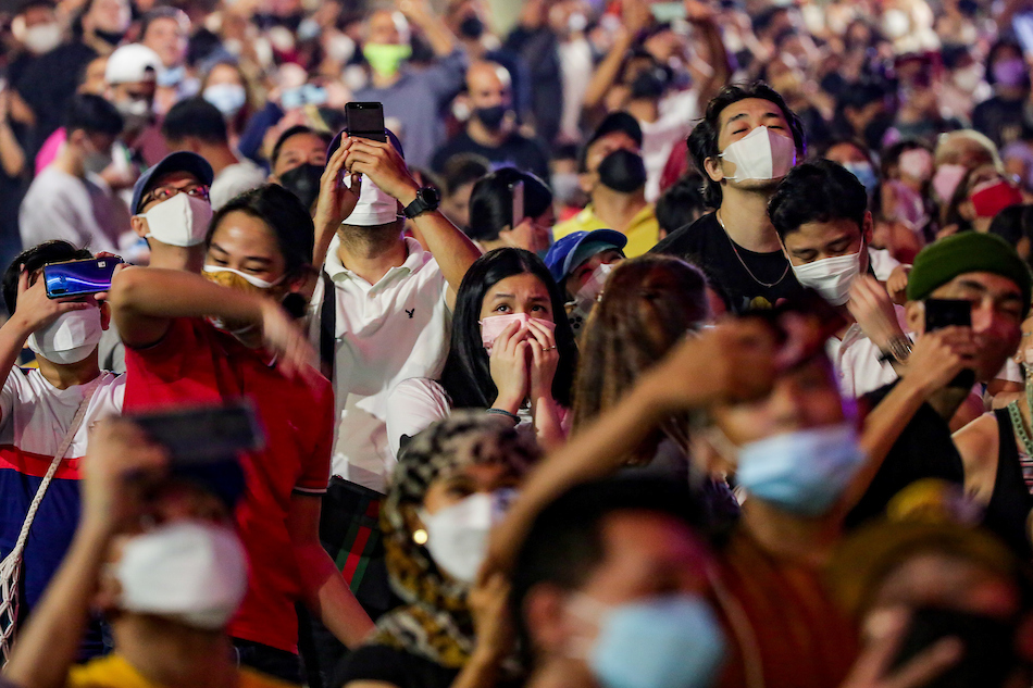Revelers watch a fireworks display at the Bonifacio High Street in BGC, Taguig City as they welcome the new year on January 1, 2022. George Calvelo, ABS-CBN News