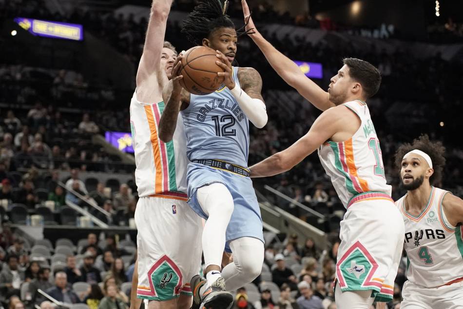 Memphis Grizzlies guard Ja Morant (12) looks to pass the ball while defended by San Antonio Spurs forward Doug McDermott (17) and center Jakob Poeltl (25) during the first half at AT&T Center. Scott Wachter, USA TODAY Sports/Reuters.