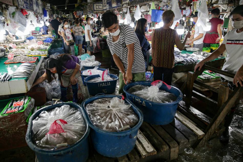People buy fish at a public market in Quezon City on January 19, 2021. George Calvelo, ABS-CBN News/FIle