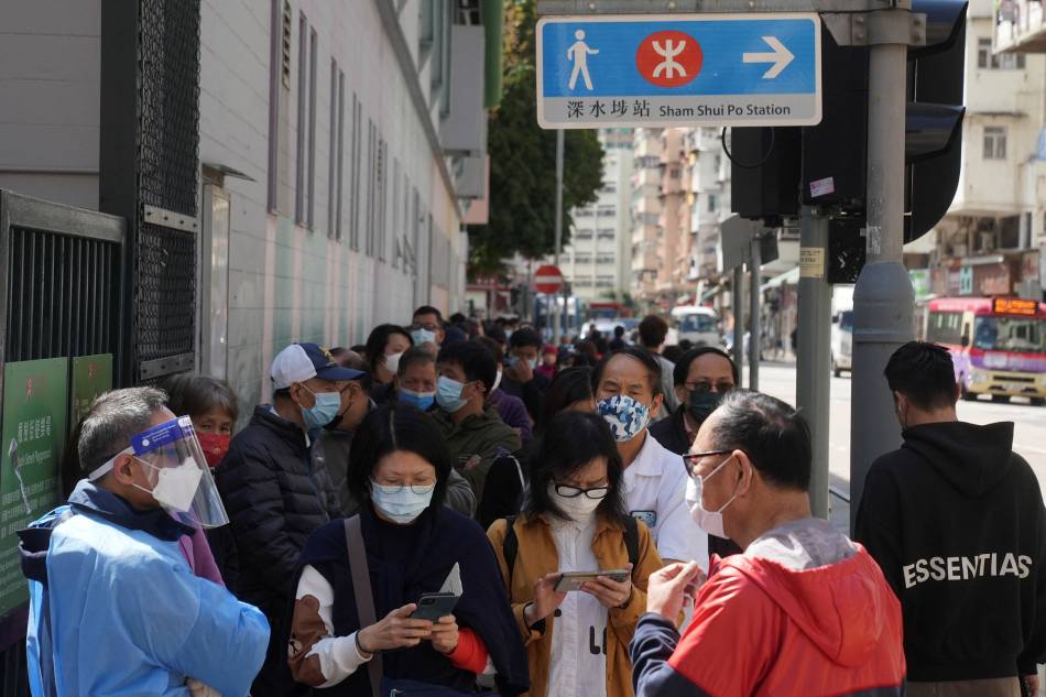 People wearing face masks queue at a makeshift testing center for the coronavirus disease (COVID-19) following the outbreak in Hong Kong, China February 14, 2022. Lam Yik, Reuters
