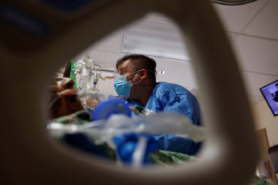 Alan Glazewski, a traveling nurse from Wisconsin treats a coronavirus disease (COVID-19) patient in the Intensive Care Unit (ICU) at St. Mary Medical Center in Apple Valley California, U.S., February 1, 2022. Shannon Stapleton, Reuters