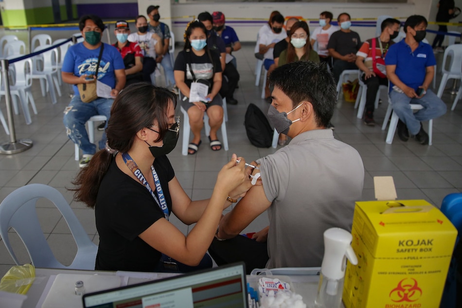 A man gets vaccinated at the LRT-2 Recto Station in Manila on February 22, 2022. The Department of Transportation (DOTr) said commuters may get their primary COVID-19 vaccine doses and booster shots at the Recto Station every Tuesday and Thursday from 8 am to 5 pm, and at the Antipolo Station, every Wednesday and Friday from 8:30 am to 4 pm. George Calvelo, ABS-CBN News