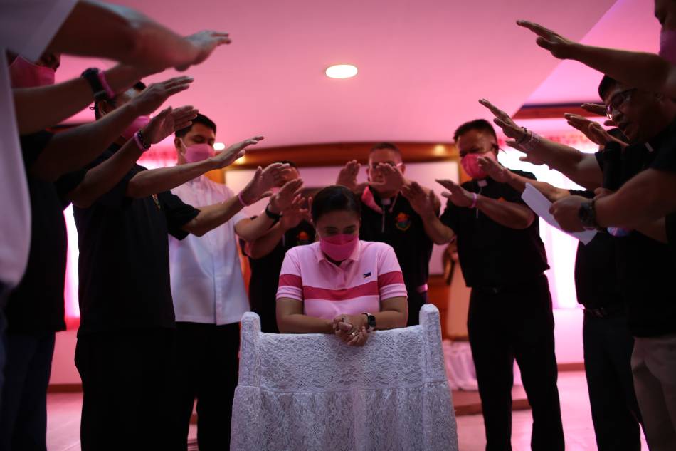 Priests at St. Augustine parish in Pinamalayan, Oriental Mindoro, pray over Vice President Leni Robredo during her visit on March 3, 2022. VP Leni Media Bureau