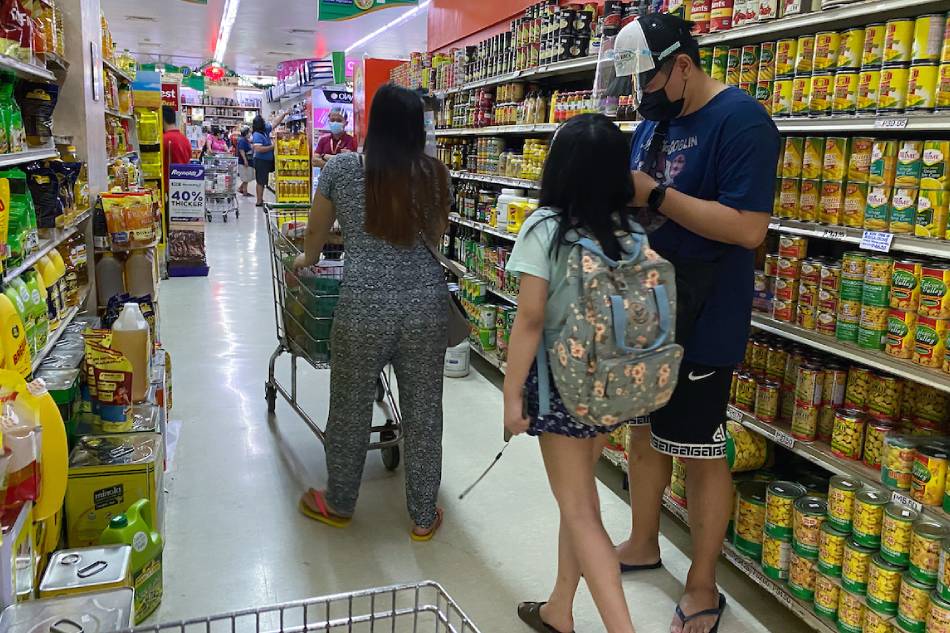 A family shops at a grocery store in Quezon City shops with a child on Nov. 14, 2021. Fernando G. Sepe Jr., ABS-CBN News