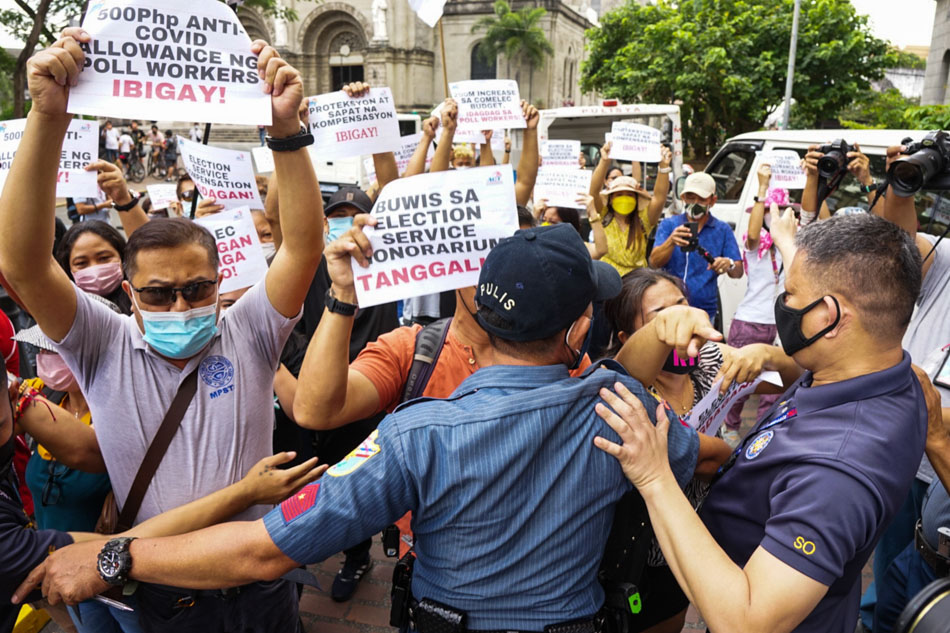 Members of Alliance of Concerned Teachers (ACT-Philippines) scuffle with policemen and security personnel during a protest outside the Commission on Elections headquarters in Intramuros, Manila on Thursday. The protesters urged the government to exempt from tax the honoraria, travel allowances and other benefits of poll workers. Mores Heramis, ABS-CBN News