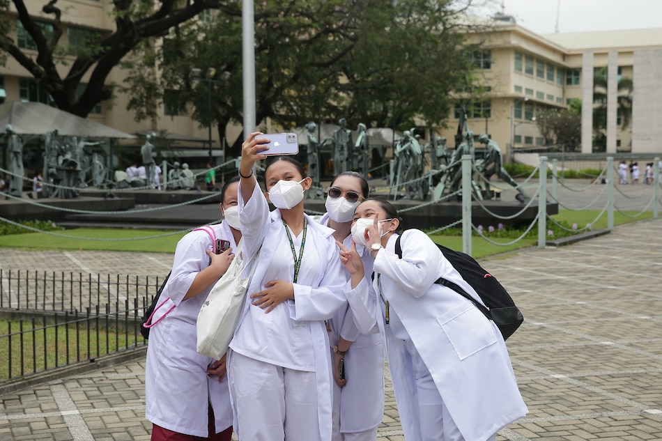 Students take selfies at the school grounds of the Far Eastern University in Manila on Feb. 23, 2022. George Calvelo, ABS-CBN News