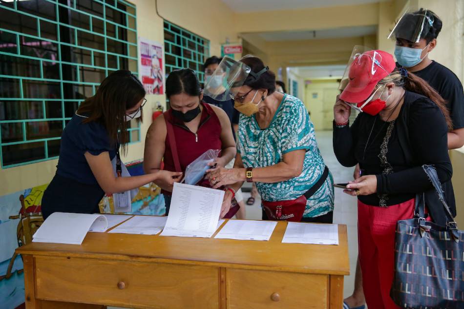 Participants search for their names during the COMELEC’s mock elections at the Padre Zamora Elementary School in Pasay City on December 29, 2021. George Calvelo, ABS-CBN News/File