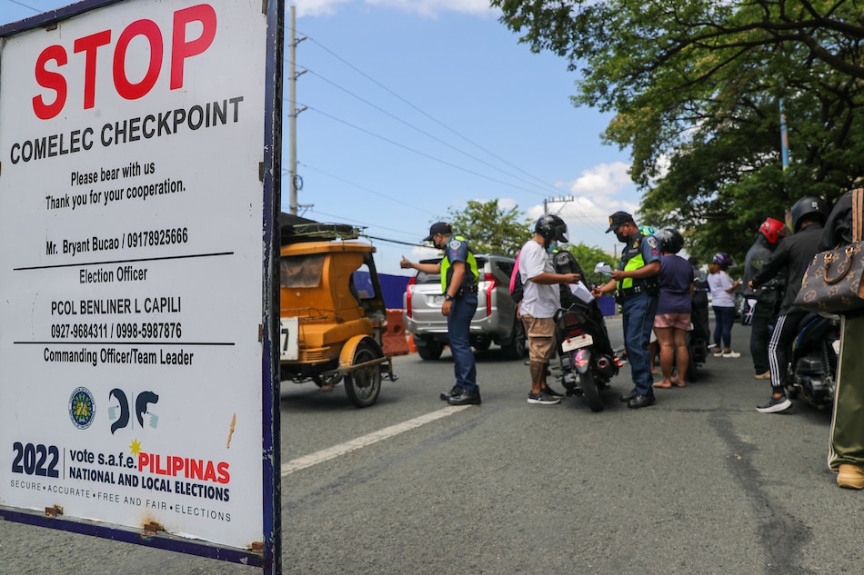 Members of the Philippine National Police (PNP) inspect documents of motorcycle riders at a PNP-Comelec checkpoint in Marikina City on April 04, 2022. Jonathan Cellona, ABS-CBN News