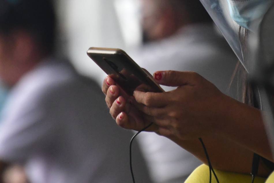 Citizens use their phones in Quezon City on August 16, 2020. Mark Demayo, ABS-CBN News/File