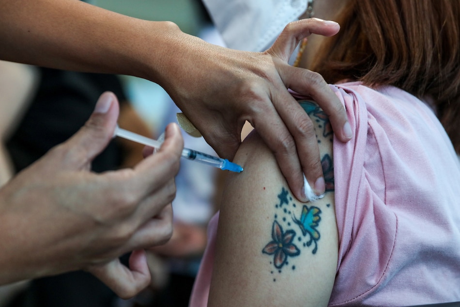 A woman gets her COVID-19 vaccine at the Mandaluyong City Hall on April 19, 2022. Jonathan Cellona, ABS-CBN News