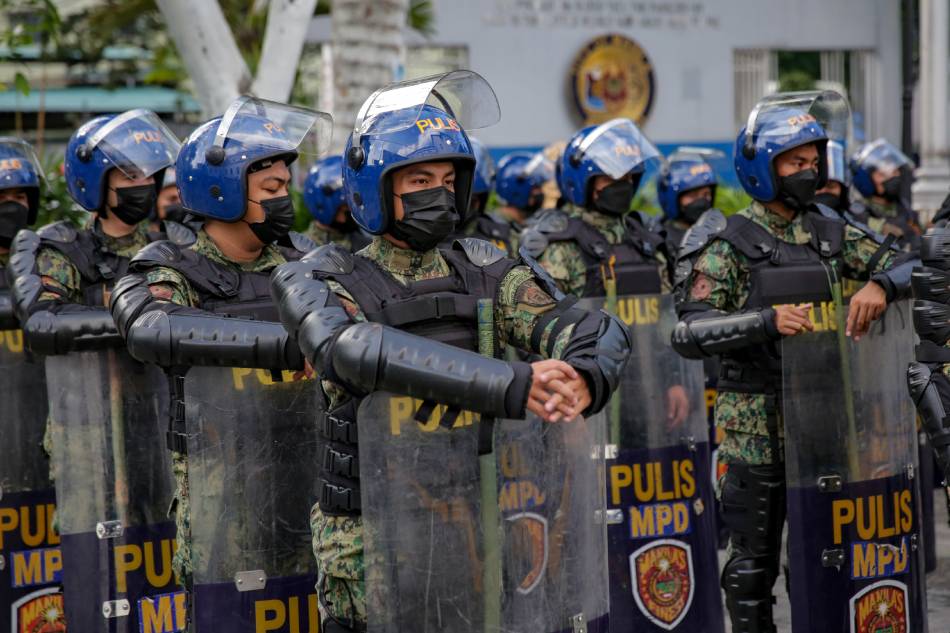 Police officers in full gear wait during an inspection inside the Manila Police District headquarters in Manila on Jan. 25, 2022. George Calvelo, ABS-CBN News 