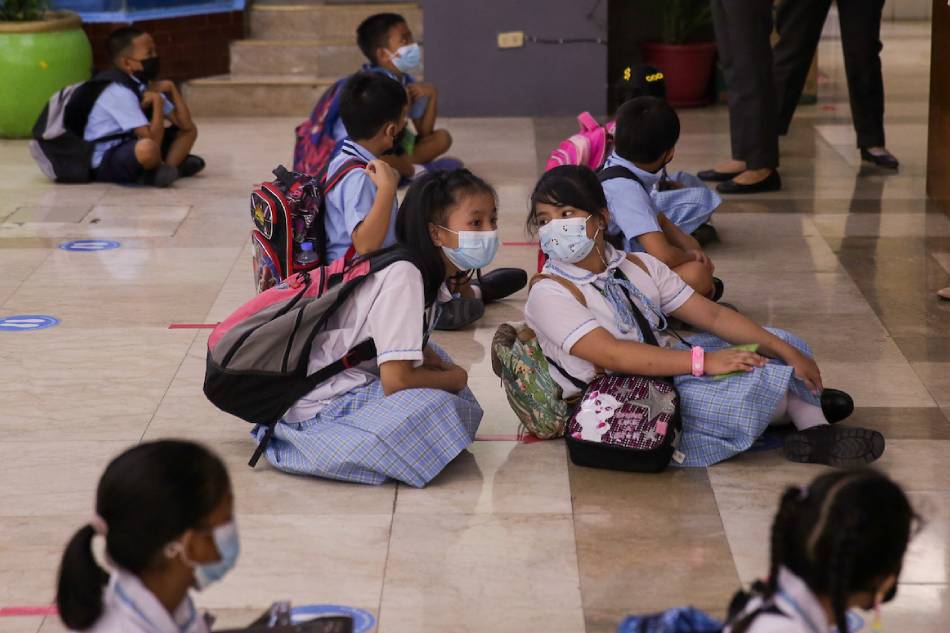 Students prepare to enter their respective classrooms at the Jose Magsaysay Elementary School (JMES) in Makati City on March 30, 2022. George Calvelo, ABS-CBN News/File
