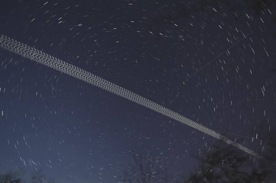 A digital stacked combination of multiple exposures shows a train of brightly-lit SpaceX Starlink 24 mission satellites pass the night sky in train formation near Herrnleis, Austria, May 9, 2021. The Starlink mass-produced satellites in low Earth orbit (LEO) work in satellite internet constellations to provide future customers with access to high-speed Internet. Christian Bruna, EPA-EFE/File