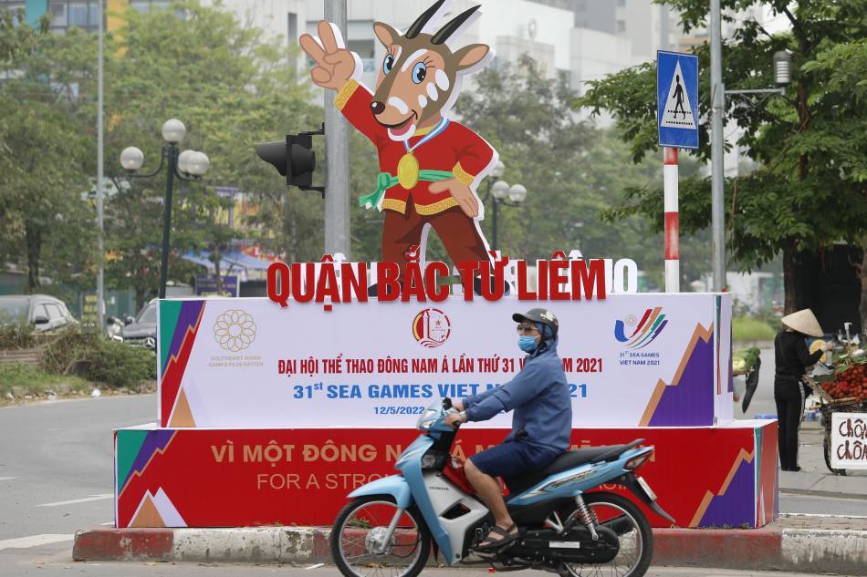 A man rides motorbike past a banner advertising the upcoming 31st Southeast Asian Games in Hanoi, Vietnam, 25 April 2022. Luong Thai Linh, EPA-EFE.