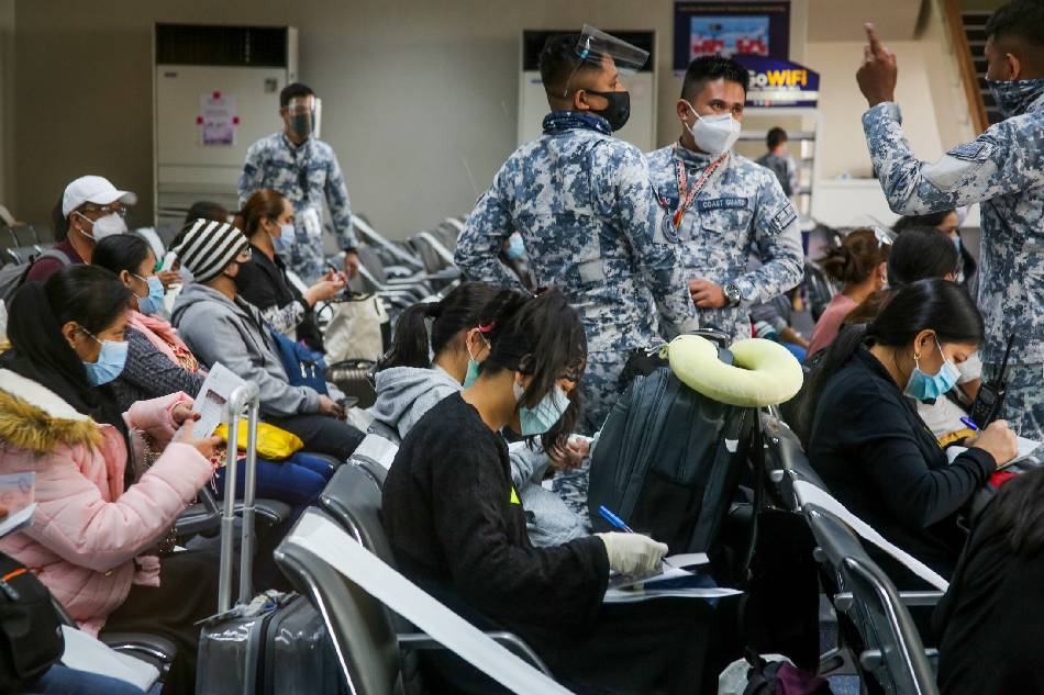 Arriving OFWs at the NAIA Terminal 1 undergo health protocols and fill out documents while being assisted by Philippine Coast Guard personnel before getting clearance from the Philippine Red Cross to get swab tests on October 28, 2020. Jonathan Cellona, ABS-CBN News/File