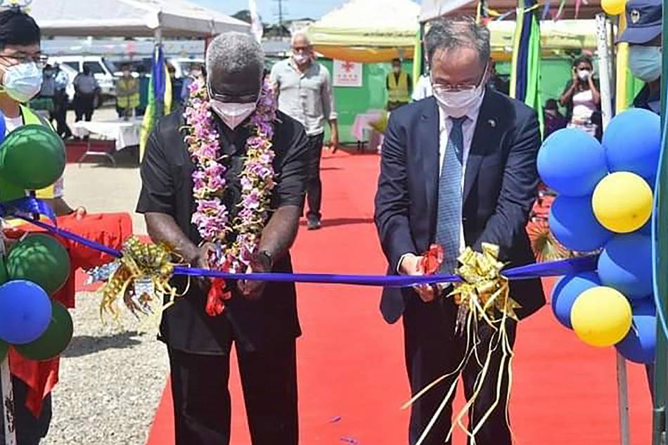 A photo taken on April 22, 2022 shows China's ambassador to the Solomon Islands Li Ming (R), and Solomons Prime Pinister Manasseh Sogavare (L) cutting a ribbon during the opening ceremony of a China-funded national stadium complex in Honiara. The stadium complex, reportedly worth 53 million USD, will host the 2023 Pacific Games for the first time in the island state of 800,000 people. Mavis Podokolo, Agence France-Presse