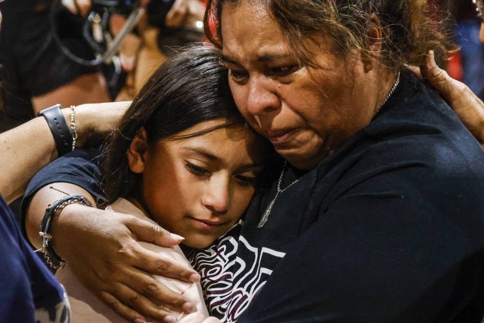 A woman cries as she hugs a child, during a community gathering at the Uvadle County Fairplex, following a mass shooting at the Robb Elementary School in Uvalde, Texas, USA, May 25, 2022. According to Texas officials, at least 19 children and 2 adults were killed in the shooting on May 24. The eighteen-year-old gunman was killed by responding officers. Tannen Maury, EPA-EFE