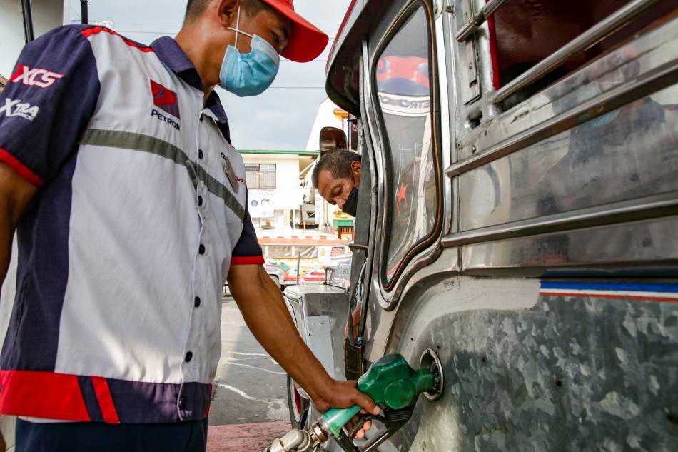 A jeepney driver refills his gas tank at a station in Manila on March 15, 2022. Motorists and commuters continue to struggle as oil prices continue to skyrocket. George Calvelo, ABS-CBN News