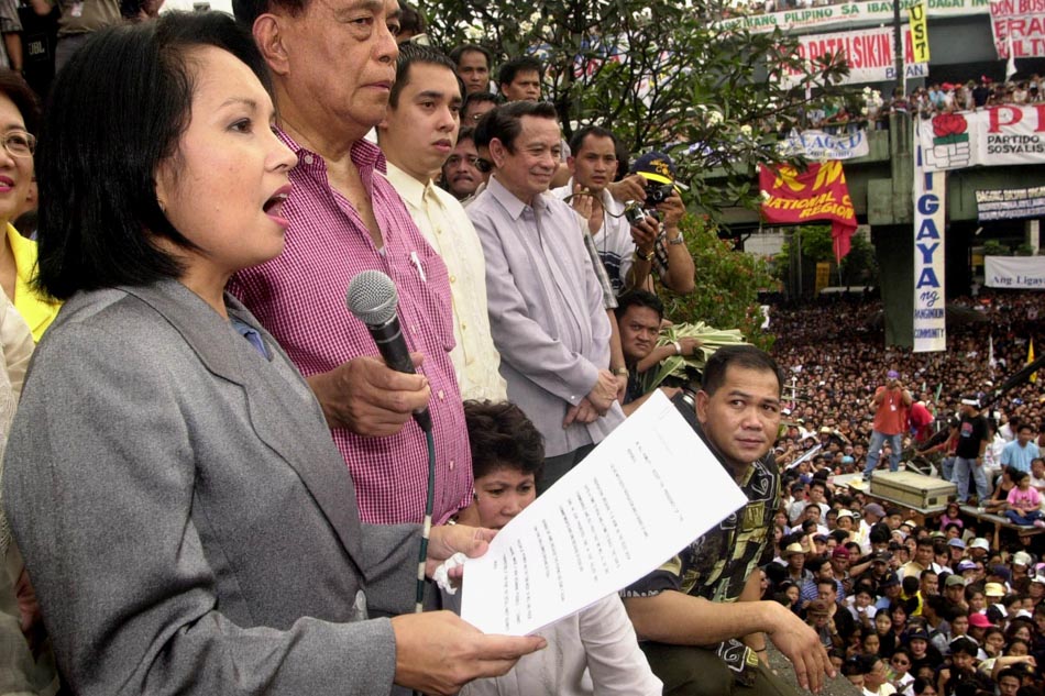 Philippine Senate president Nene Pimentel (2nd left) holds a microphone for new Philippines President Gloria Macapagal Arroyo (left) as she addresses thousands of her supporters in Manila, 20 January 2001, moments after being sworn in as the new president. Joel Nito, AFP