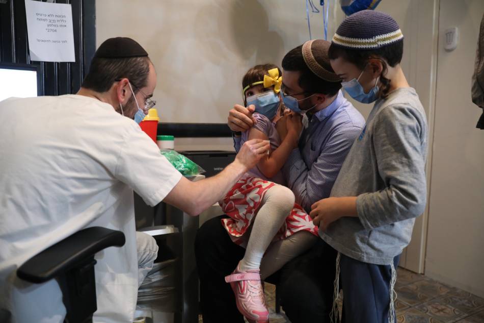 A nurse injects a child with a first shot of a COVID-19 vaccine in Jerusalem, Israel, 23 November 2021. Israel launched a campaign to offer Covid-19 vaccine dose for children between 5 and 12 years old EPA-EFE/ABIR SULTAN