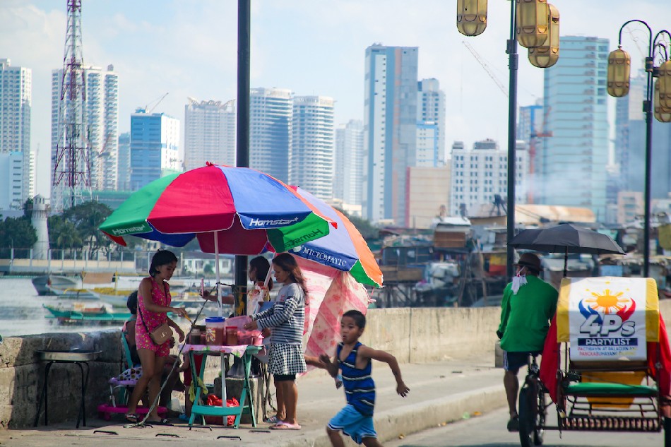 People buy from a food vendor in Baseco, Tondo, Manila on February 9, 2022. Jonathan Cellona, ABS-CBN News/file