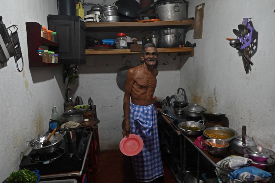 This photo taken on July 17, 2022 shows Milton Pereira looking on in his kitchen in the Slave Island neighborhood of Colombo. In the face of a months-long economic crisis that has seen rampant inflation and protests that last week brought down the president, Sri Lankans are buying less, eating less and working less. Arun Sankar / AFP